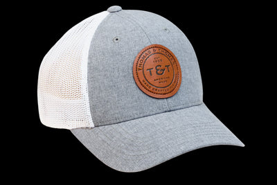 Thomas & Thomas Rods & Accessories - Heather grey trucker hat with white mesh and leather T&T badge sewn in the center. Back strap has 1969 embroidered on it in navy.