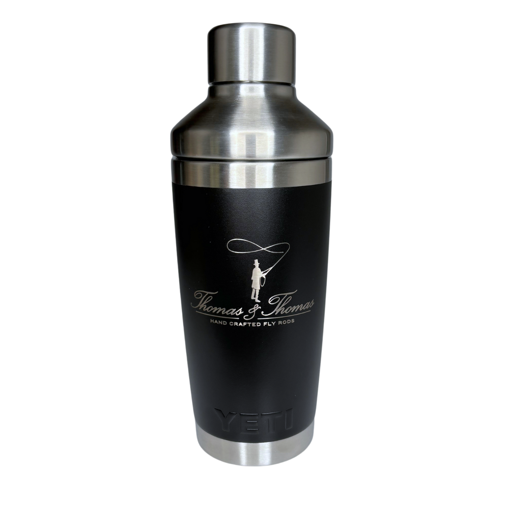 Thomas & Thomas Rods & Accessories - Black 20oz YETI Rambler Tumbler with Stainless Steel Cocktail Shaker Lid. Thomas and Thomas script lettering in the middle center with a pilgrim man casting a fly rod on the top and the text "Hand Crafted Fly Rods" on the third line. 